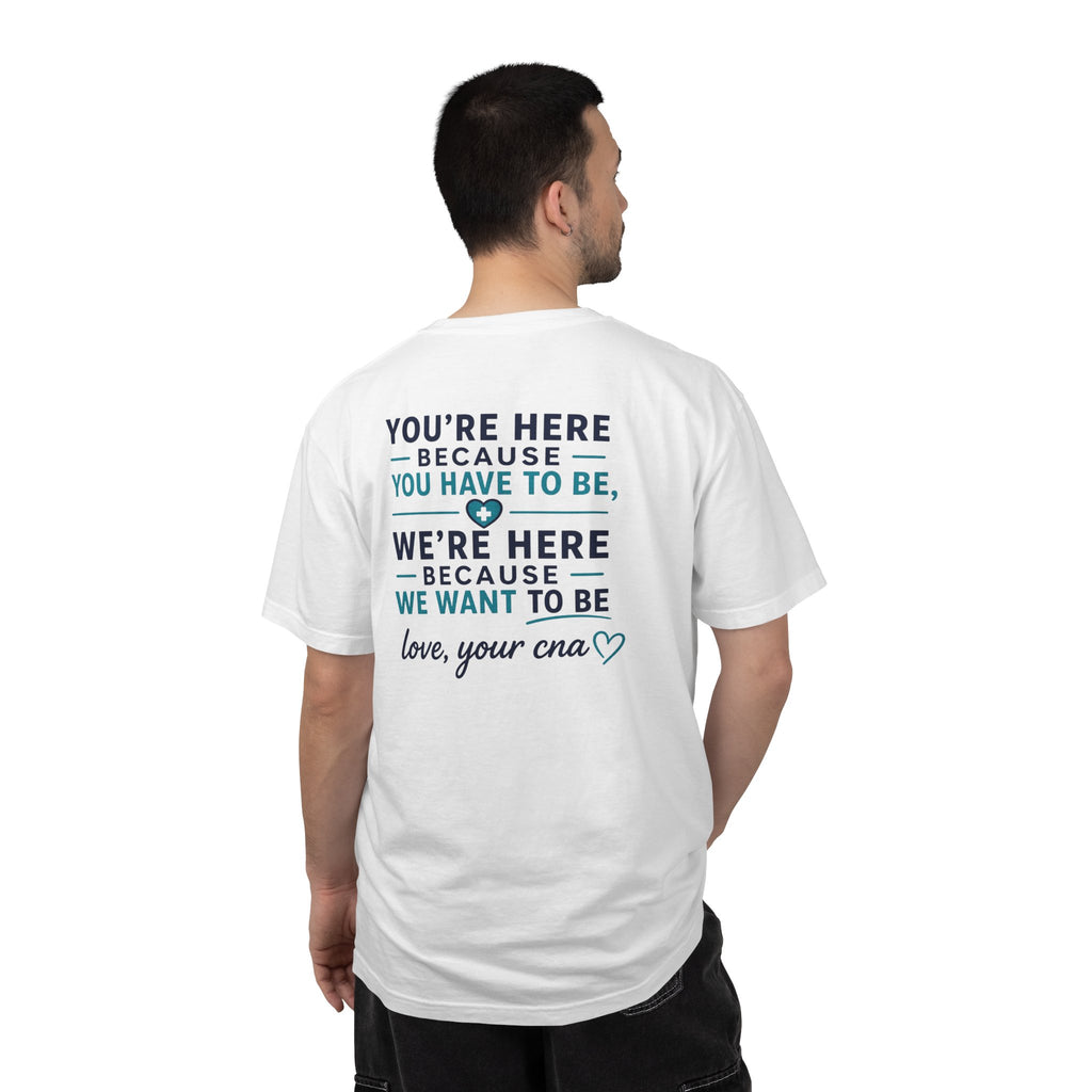 CNA T-Shirt — "We're Here Because We Want To Be" Heartfelt CNA Gift | Unisex Heavyweight Garment-Dyed Tee