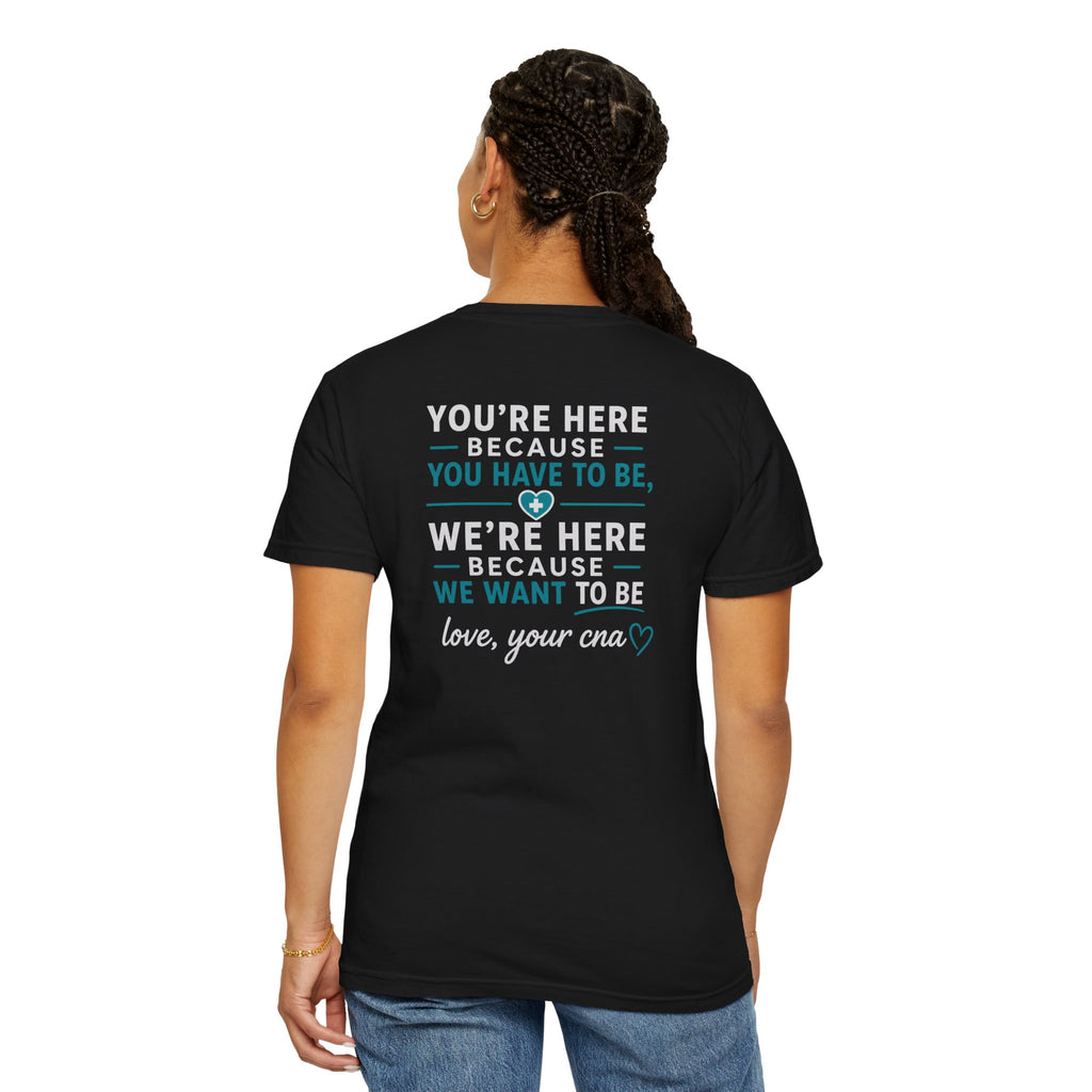 CNA T-Shirt — "We're Here Because We Want To Be" Heartfelt CNA Gift | Unisex Heavyweight Garment-Dyed Tee